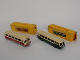 three toy buses sitting next to each other on a white surface