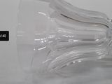 a clear wine glass with a curved stem on a table