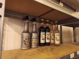bottles of alcohol are lined up on a shelf in a kitchen