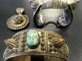 deux bracelets en argent et un bracelet en turquoise posés sur une table