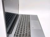 a silver laptop with a black keyboard on a white surface