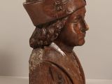 carved wooden bust of a man with a hat on top of his head