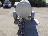a trailer with a tank attached to it in a parking lot
