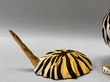 a zebra print vase next to an umbrella on a table