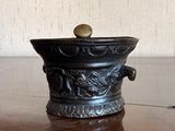 a black vase with a gold ball on top of it