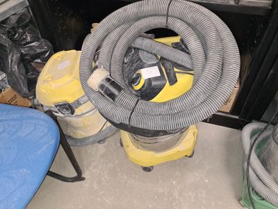 un aspirateur jaune et noir posé à côté d'une chaise bleue