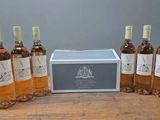 six bouteilles de vin posées sur une table en bois, à côté d'une boîte