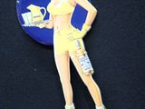 un pin's représentant une femme en robe jaune