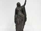 une statue en bronze représentant une femme tenant un oiseau dans la main