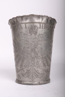 un vieux vase en argent orné d'un blason