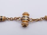an image of a gold bracelet with tassels on a chain