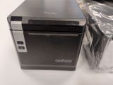 a small black computer sitting on a table next to a plastic bag