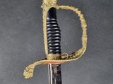 an old sword with a gold handle on a black background