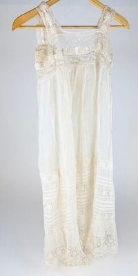 an image of a white dress hanging on a wooden hanger
