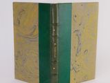 a green and gold book that is open on a white surface