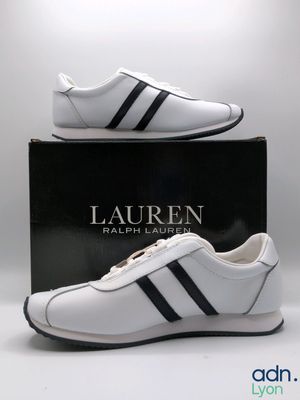 un gros plan sur une paire de chaussures blanches à rayures noires