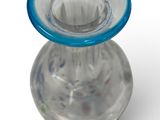 a clear glass vase with a blue rim on a white background