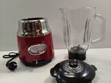 a red blender sitting next to a red blender on a counter