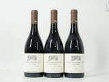 trois bouteilles de vin rouge sont posées sur une surface blanche
