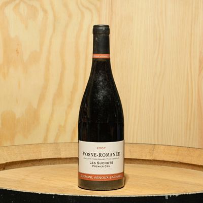 a bottle of wine sitting on top of a barrel