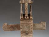 an image of a wooden sculpture of a man holding a knife