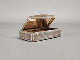 an antique silver box with a lid on a table