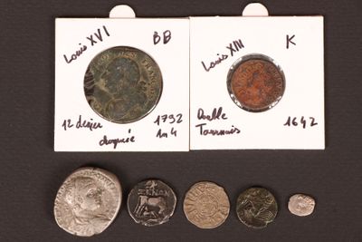 several different types of coins are shown on a black surface