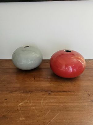 two vases sitting on a wooden table next to each other