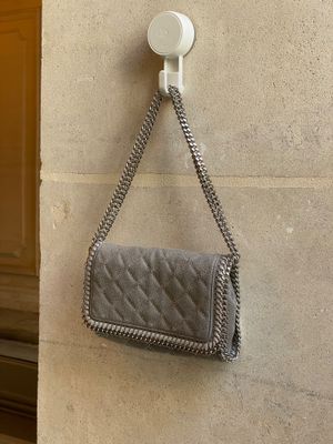 un sac à main accroché au mur, auquel est fixé un téléphone