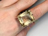 someone is holding a ring with a green stone in it