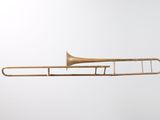 an old brass trombone is shown against a white background