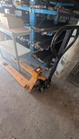 Dans un garage en face : 1 transpalette peseur