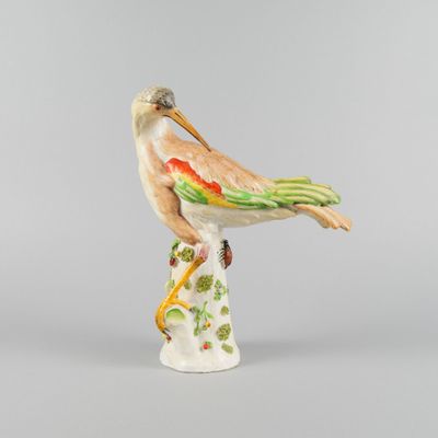 figurine en porcelaine représentant un oiseau perché sur une souche d'arbre