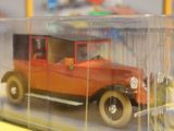 an orange toy car in a clear case on a table
