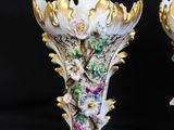pair of porcelain vases decorated with flowers and leaves on a black background