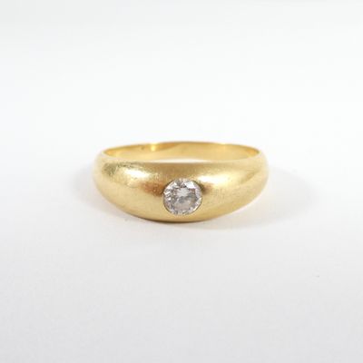 gros plan d'une bague en or avec un diamant au centre
