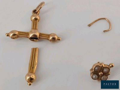 a gold cross and a pair of earrings on a table