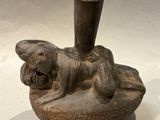 a small vase with a dog on it on a table
