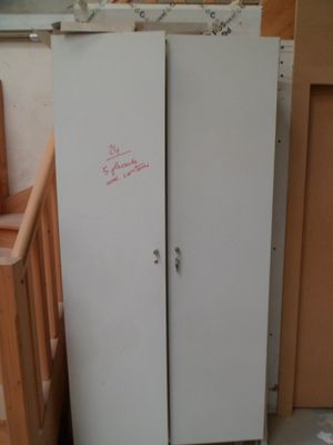 deux réfrigérateurs situés dans une pièce dont les murs ne sont pas finis