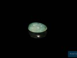 un gros plan d'une pierre de jade verte sur une surface noire