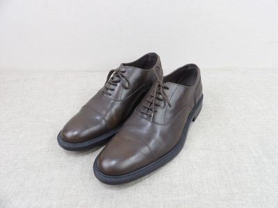une paire de chaussures marron posées sur une surface blanche