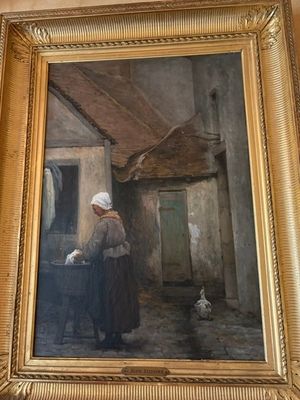 un tableau représentant une femme avec un chat devant un immeuble