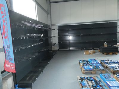 many empty shelves in a store with many different items
