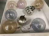 six boules de Noël en verre dans une boîte posée sur une table