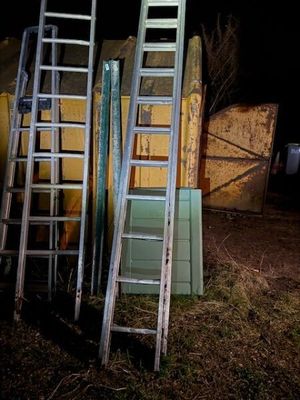 de nombreuses échelles appuyées contre un mur dans l'obscurité