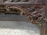 a close up of a wooden bench with carvings on it