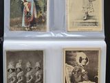 Plusieurs vieilles photos de personnes en costume sont exposées sur une table