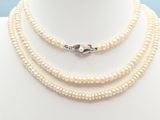 a white pearl necklace with a silver clasp on a mannequin