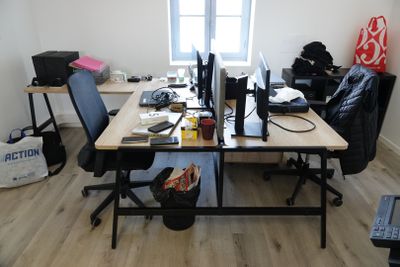 un bureau sur lequel se trouvent deux ordinateurs, dans une pièce
