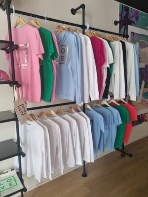 many shirts hanging on a rack in a store